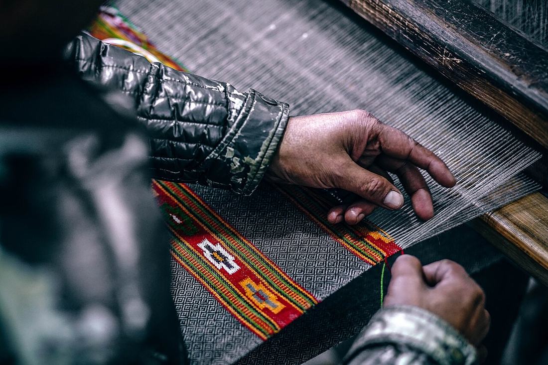 Mãos trabalhando em um tear